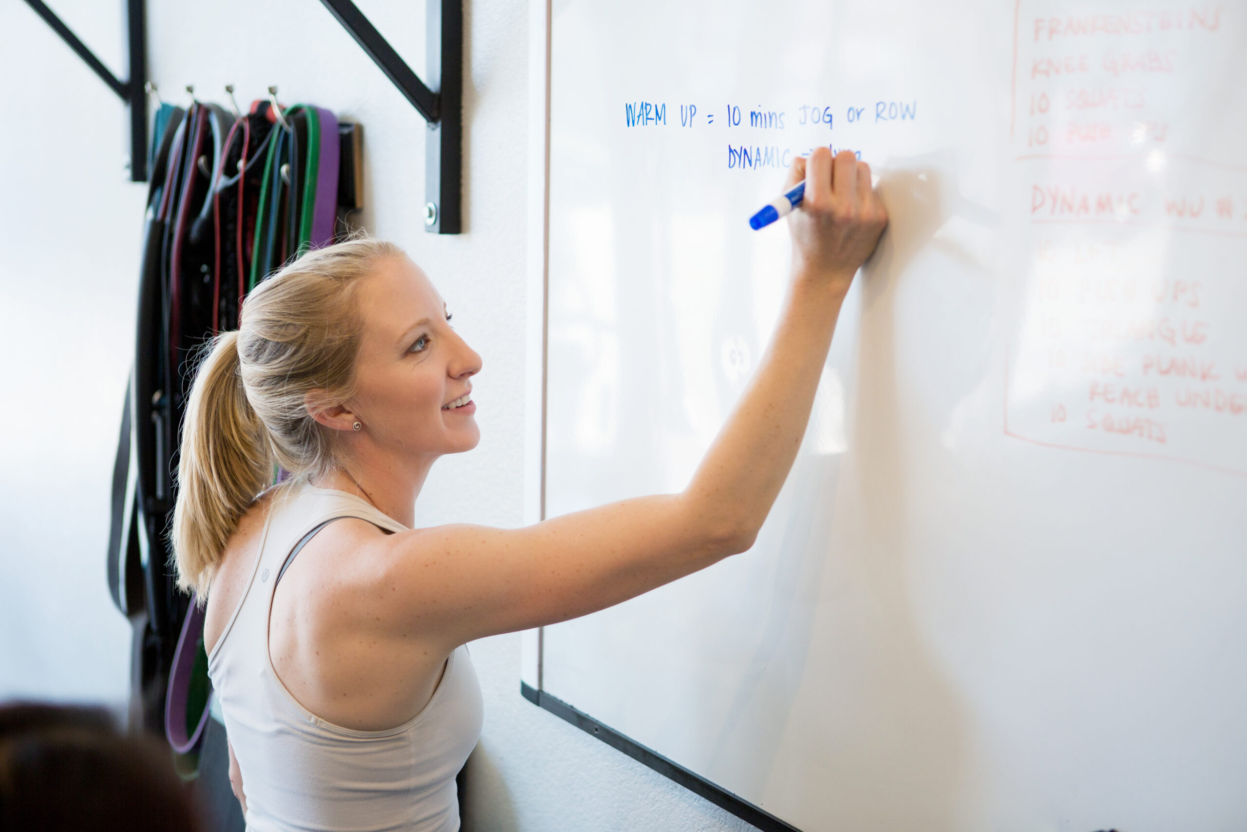 Kristin Hedstrom writing a training workout on a white board